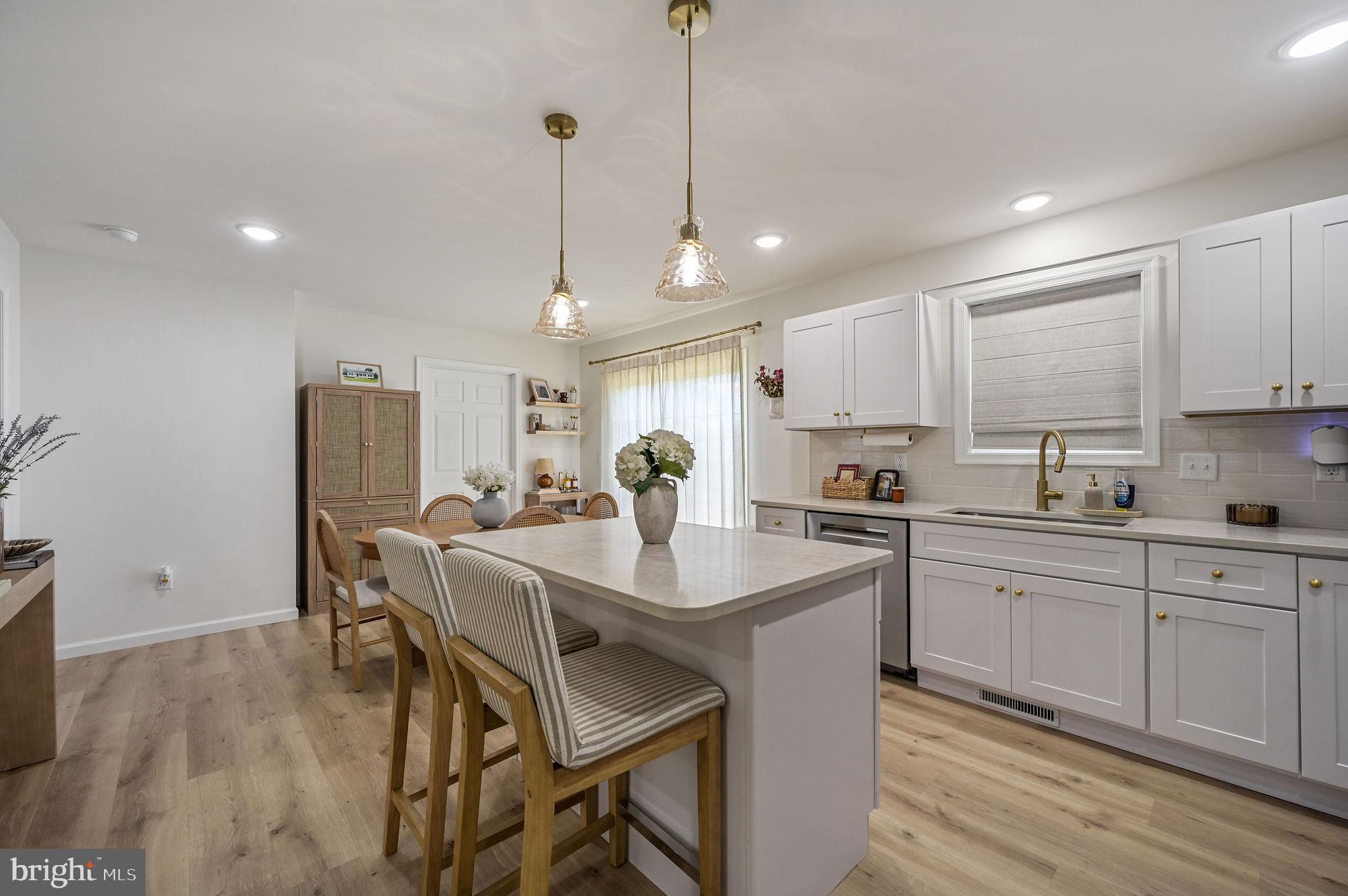 7 Porter Street Harrington, DE 19952 - Photo 4 of 24 a kitchen with stainless steel appliances granite countertop a sink a stove a refrigerator and white cabinets with wooden floor