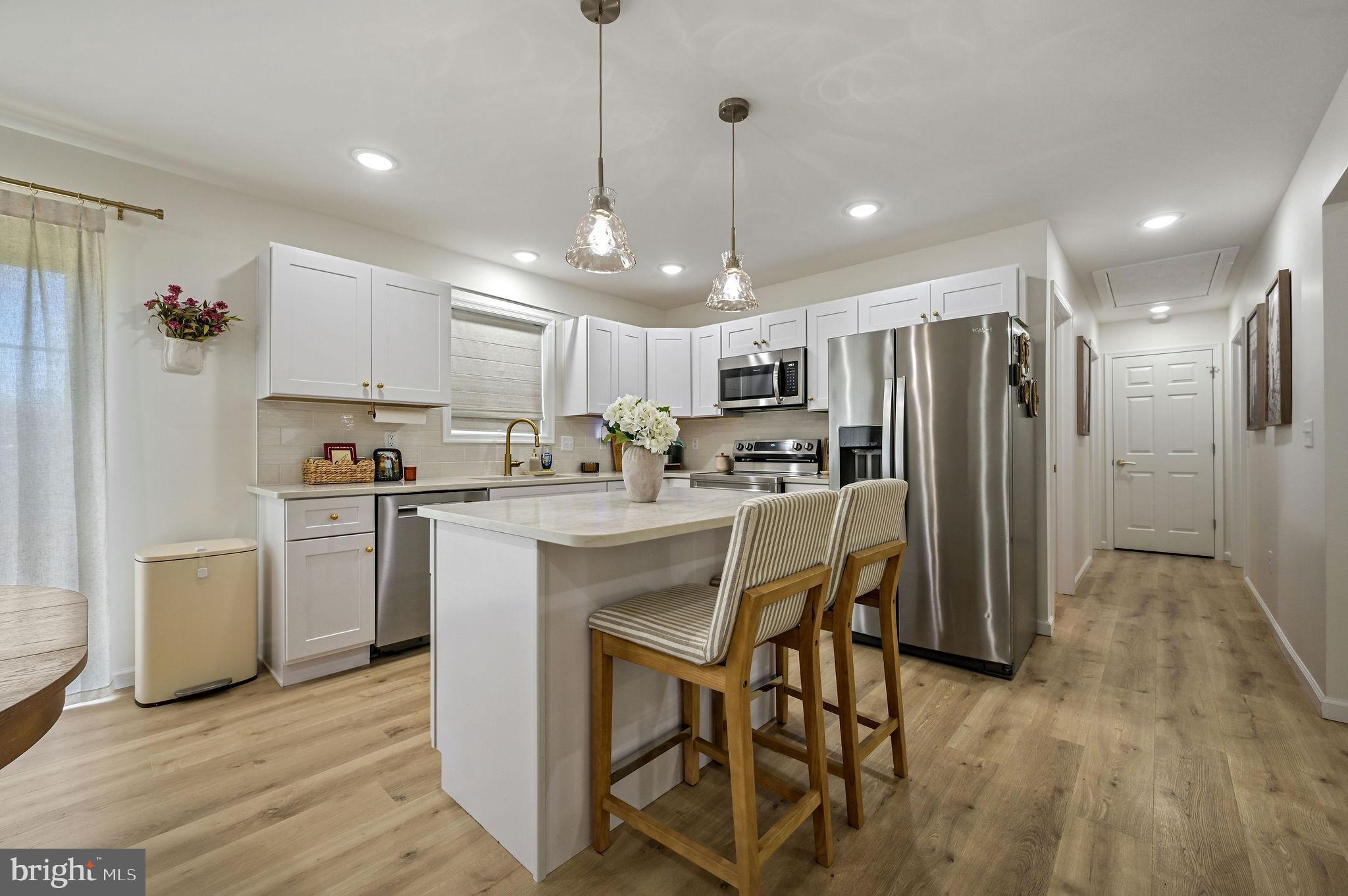 7 Porter Street Harrington, DE 19952 - Photo 6 of 24 a kitchen with refrigerator a sink and chairs