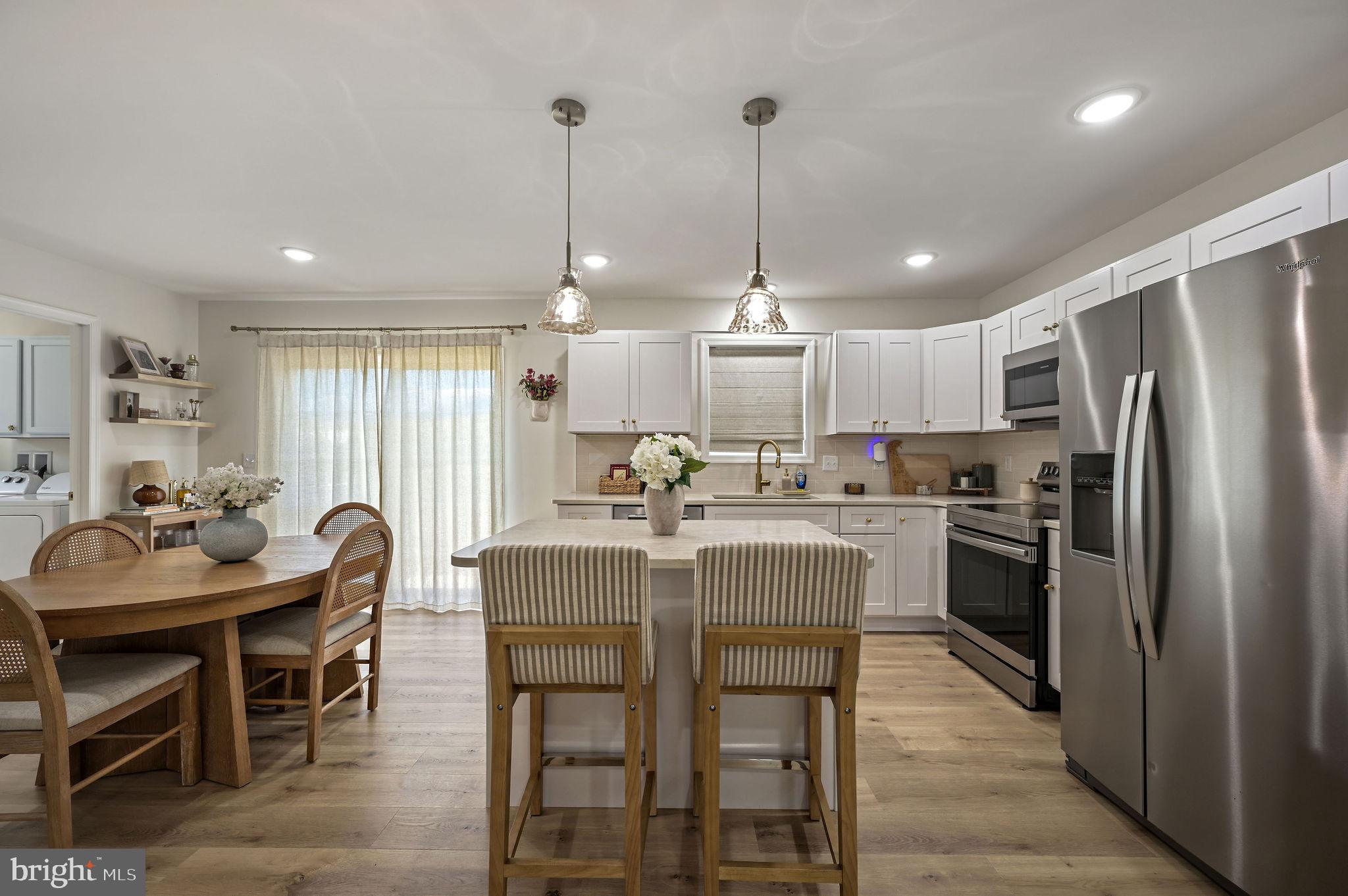 7 Porter Street Harrington, DE 19952 - Photo 9 of 24 a kitchen with stainless steel appliances granite countertop a table chairs stove and refrigerator