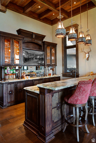 2322 North Westward Ho Road Heber City, UT 84036 - Photo 21 of 54 Indoor wet bar with glass insert cabinets, dark wood finish cabinets, a high wood beamed ceiling, dark wood-style floors, and decorative light fixtures