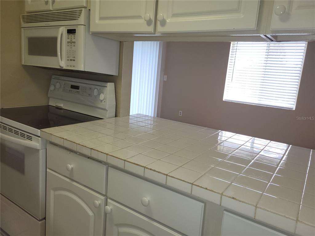 2707B Hidden Lake Boulevard, Unit D Sarasota, FL 34237 - Photo 8 of 20 a kitchen with a cabinets and window
