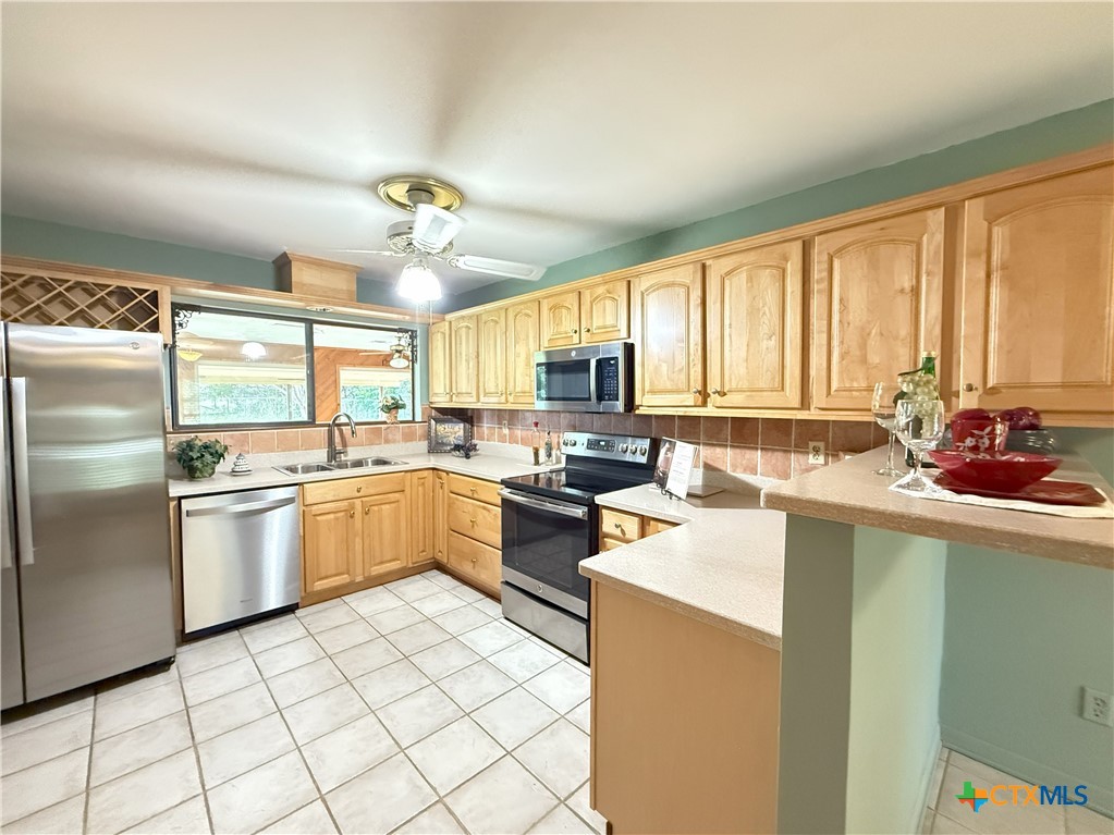 659 County Road 4744 Kempner, TX 76539 - Photo 16 of 48 a kitchen with a refrigerator a sink dishwasher with a dining table and chairs