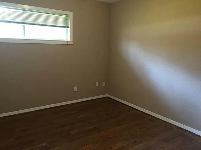 a view of a small space with wooden floor and a window