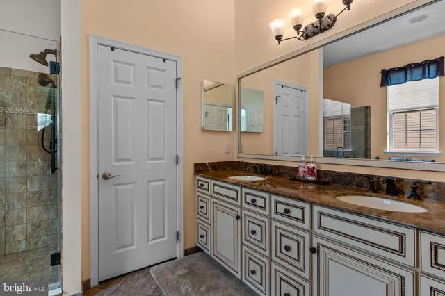 a bathroom with a double vanity sink mirror and shower