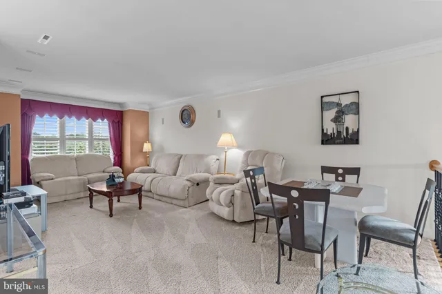 a living room with furniture a flat screen tv and kitchen view