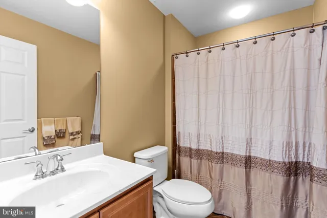 a bedroom with a bed and a flat tv screen on dresser