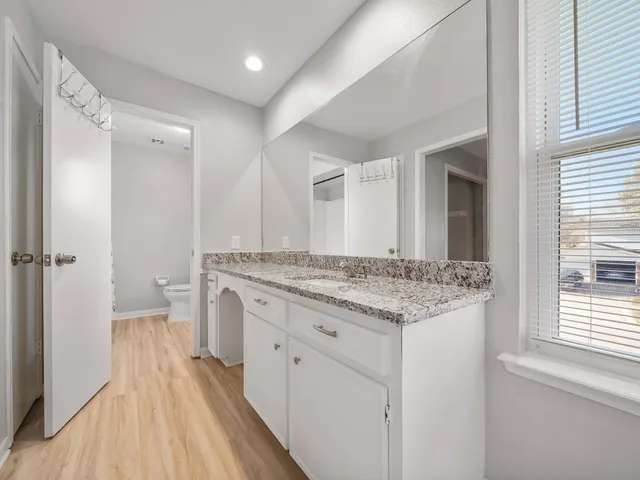 a bathroom with a granite countertop sink and a mirror