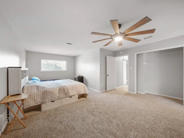 a spacious bedroom with a bed and a chandelier