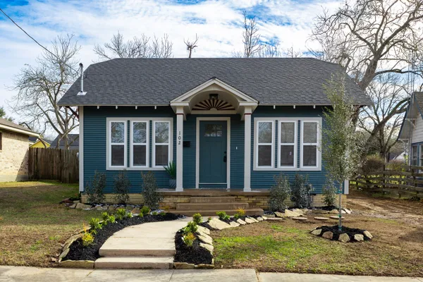 a front view of a house with a yard and glass windows