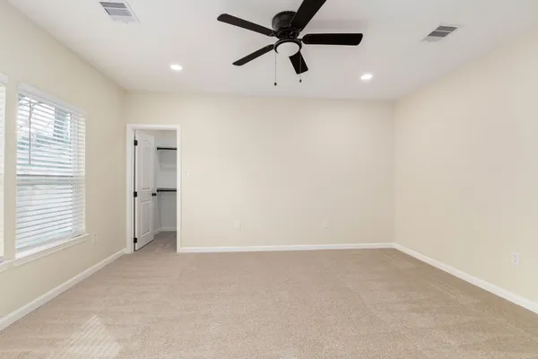 an empty room with a window and a fan