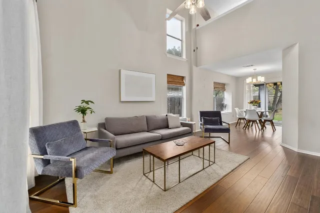 a living room with furniture a wooden floor and a chandelier