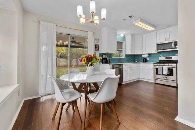 a view of a dining room with furniture a chandelier and wooden floor