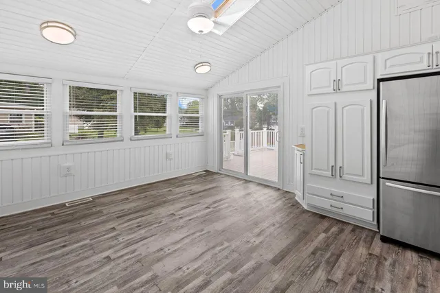 an empty room with wooden floor and a window