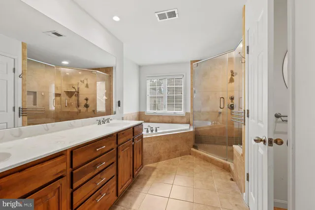a spacious bathroom with a granite countertop tub sink shower and mirror