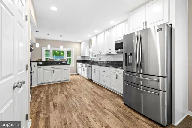 a kitchen with stainless steel appliances a refrigerator sink and cabinets