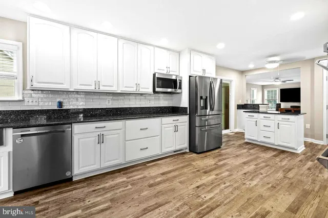 a kitchen with stainless steel appliances a refrigerator sink and microwave