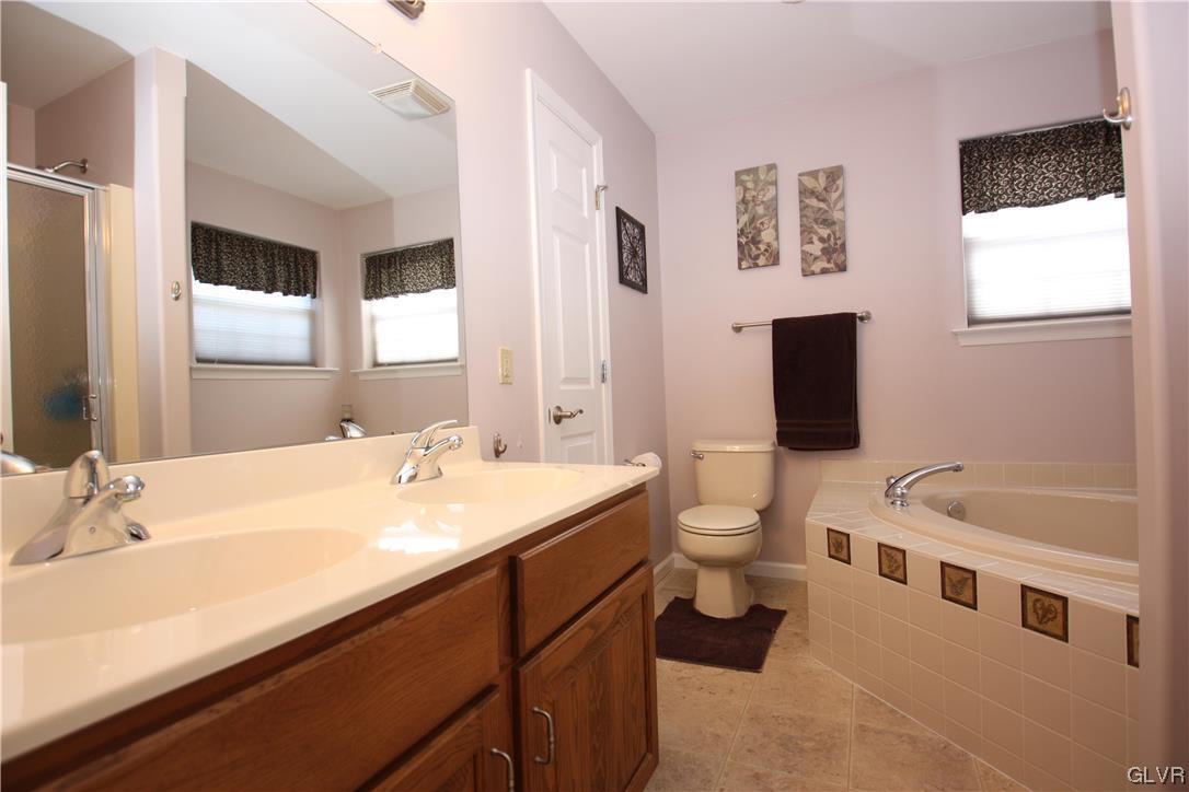 3838 Rittenhouse Road Lower Macungie Township, PA 18062 - Photo 12 of 26 a bathroom with a double vanity sink a toilet and mirror