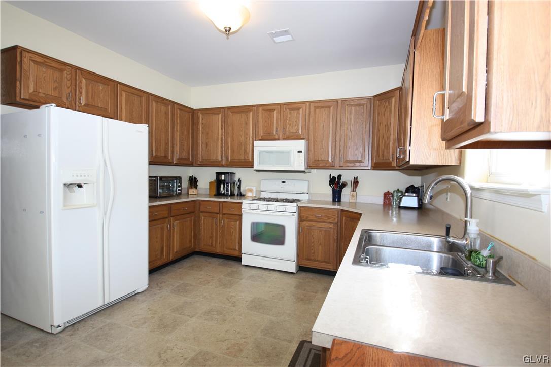3838 Rittenhouse Road Lower Macungie Township, PA 18062 - Photo 8 of 26 a kitchen with white cabinets and white appliances