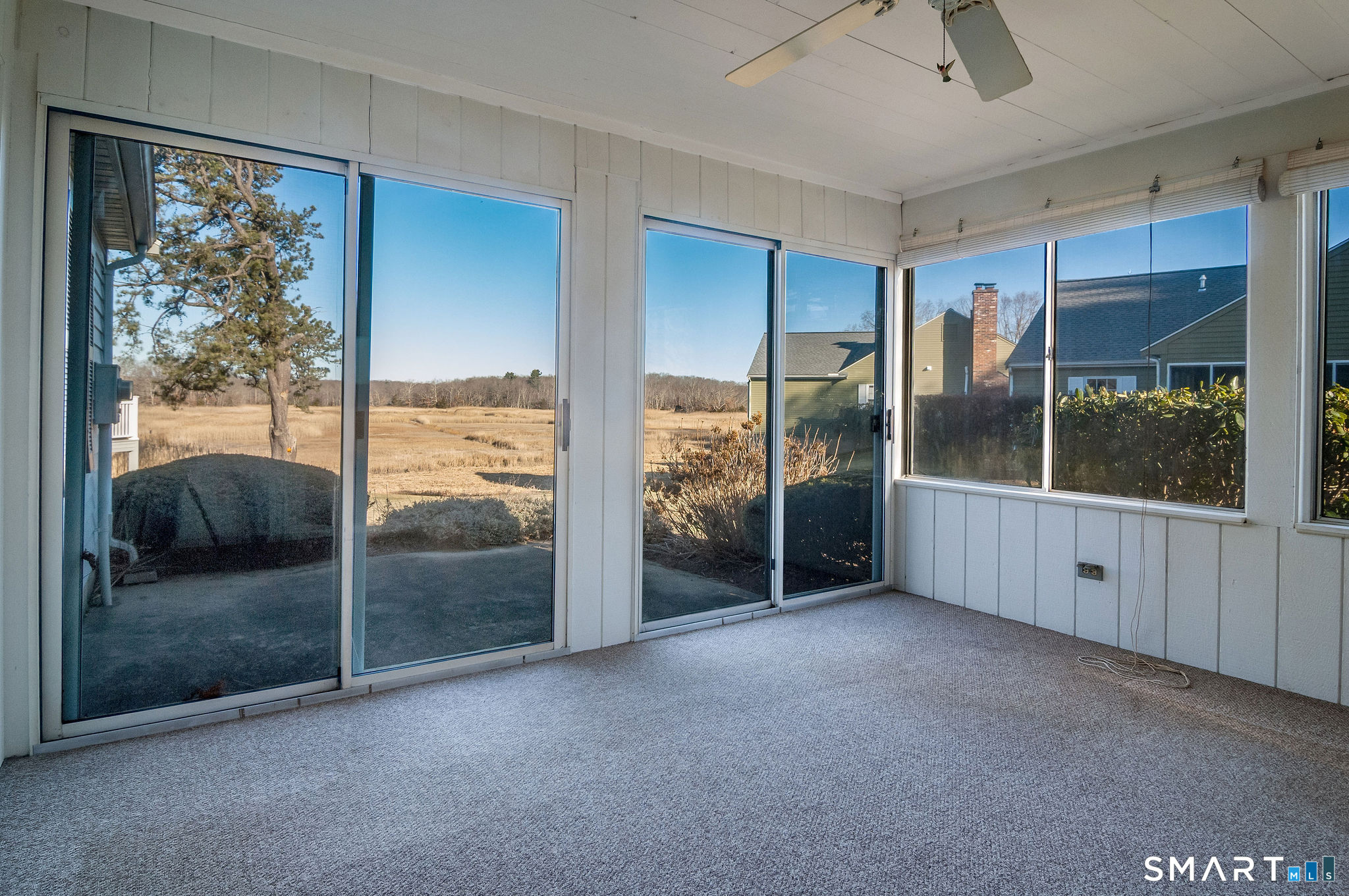 1 Downing Way, Unit 1 Madison, CT 06443 - Photo 15 of 26 a view of an empty room with sliding glass door and windows