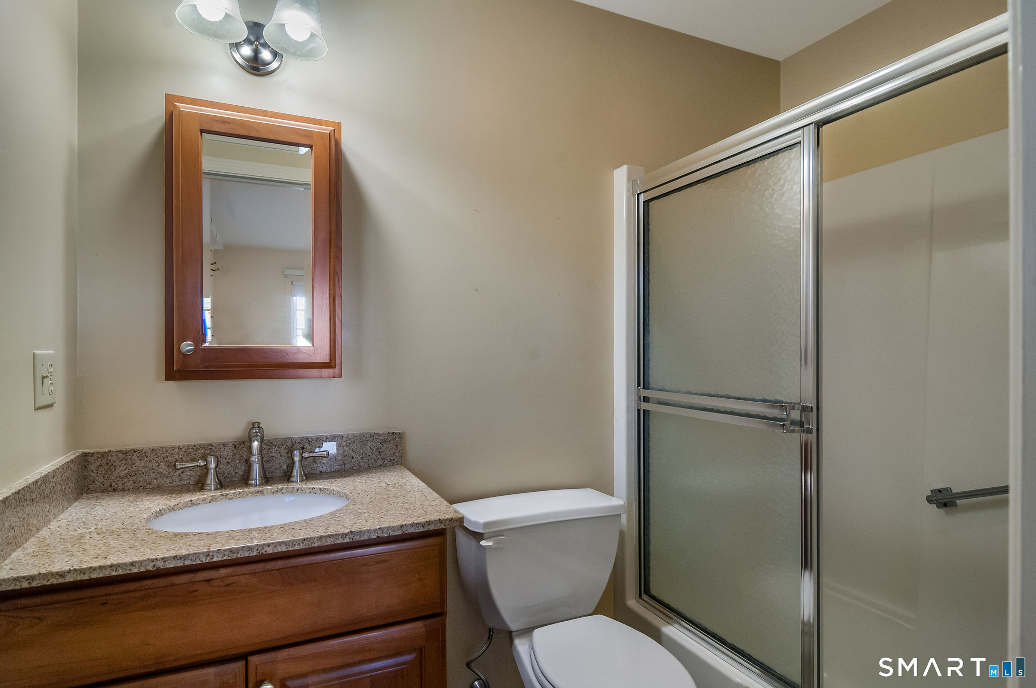 1 Downing Way, Unit 1 Madison, CT 06443 - Photo 18 of 26 a bathroom with a granite countertop toilet sink and mirror