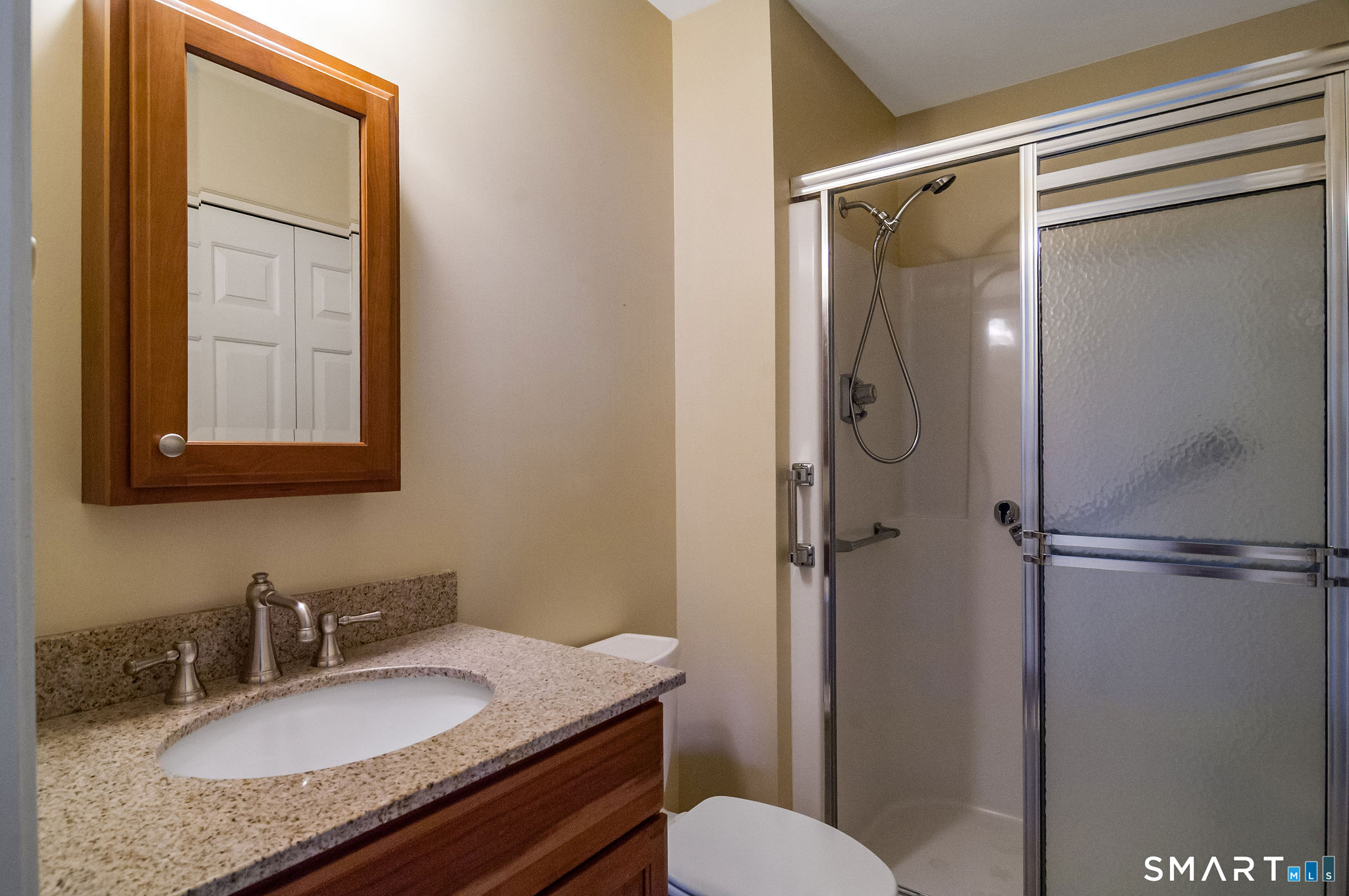 1 Downing Way, Unit 1 Madison, CT 06443 - Photo 20 of 26 a bathroom with a granite countertop sink toilet and shower