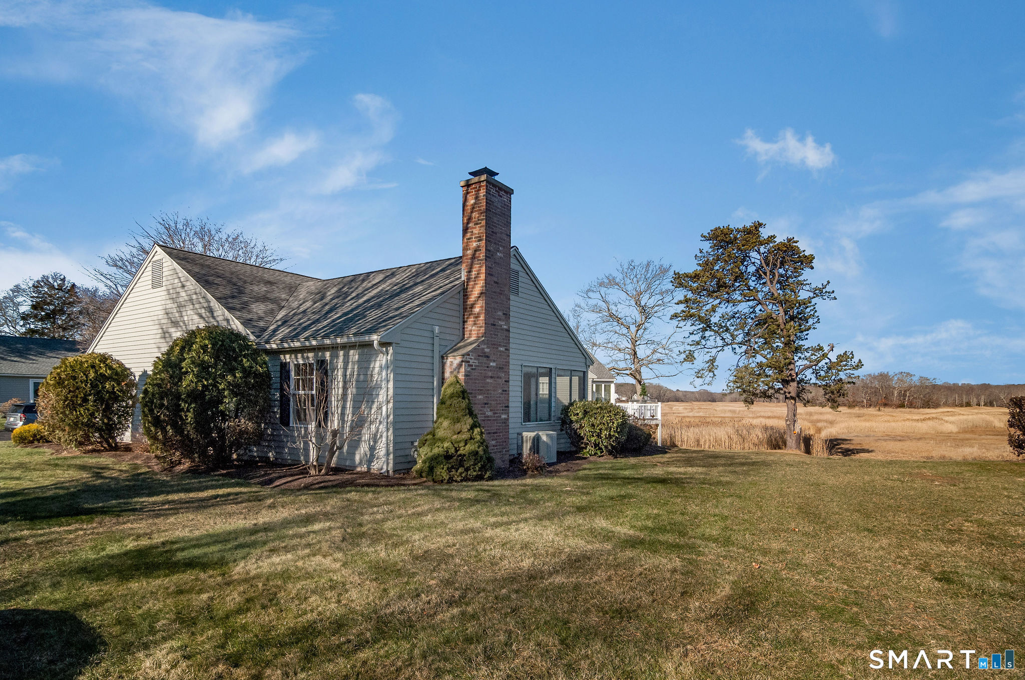 1 Downing Way, Unit 1 Madison, CT 06443 - Photo 2 of 26 a front view of house with yard and trees around