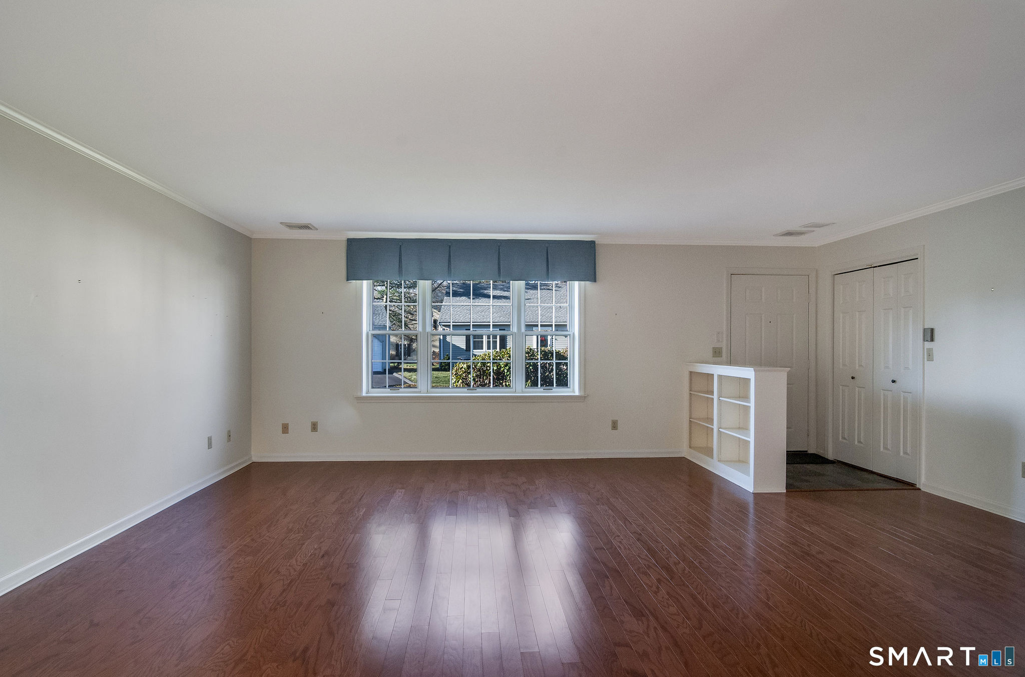 1 Downing Way, Unit 1 Madison, CT 06443 - Photo 7 of 26 a view of an empty room with wooden floor and a window
