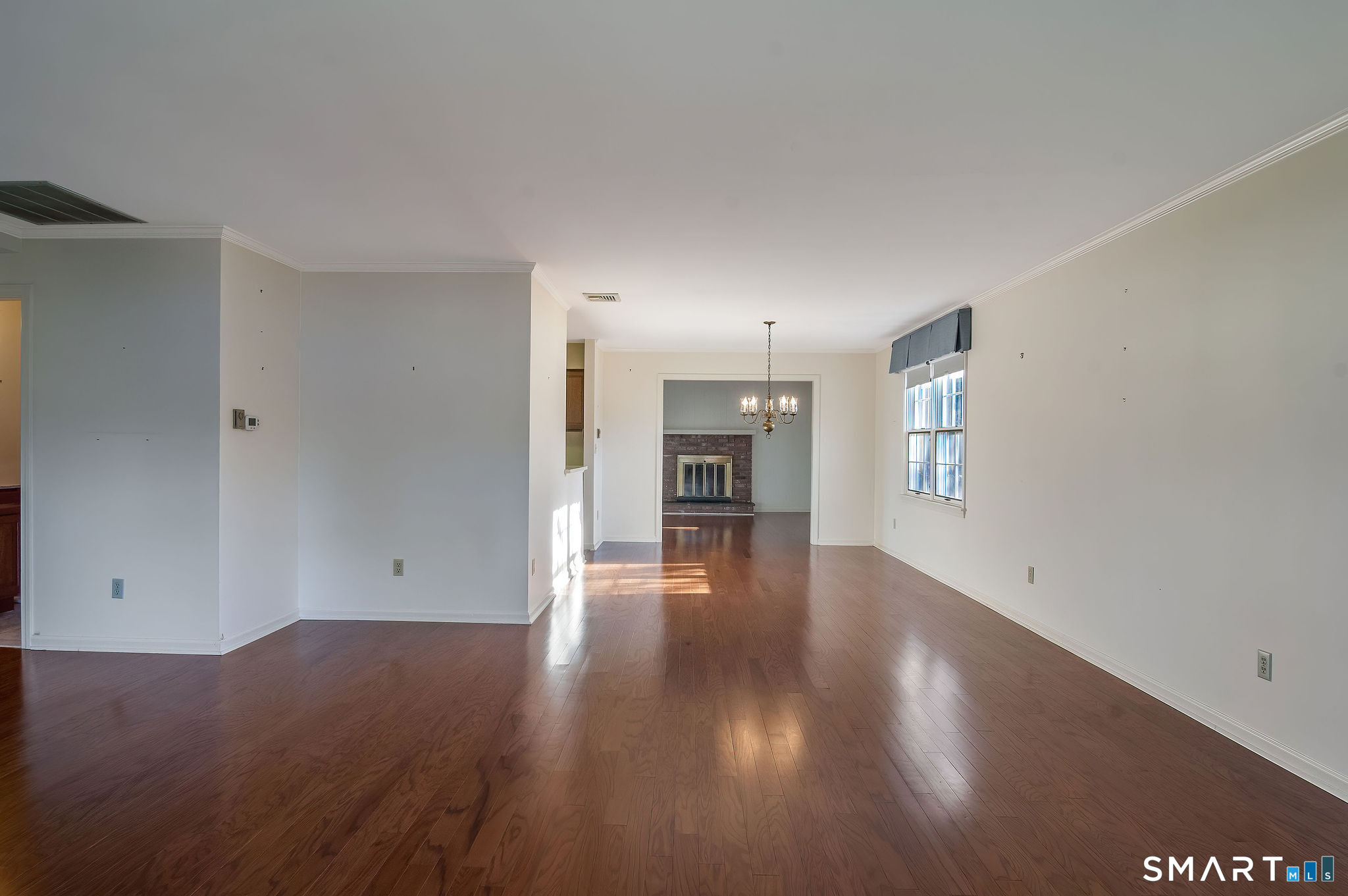 1 Downing Way, Unit 1 Madison, CT 06443 - Photo 8 of 26 an empty room with wooden floor fireplace and windows
