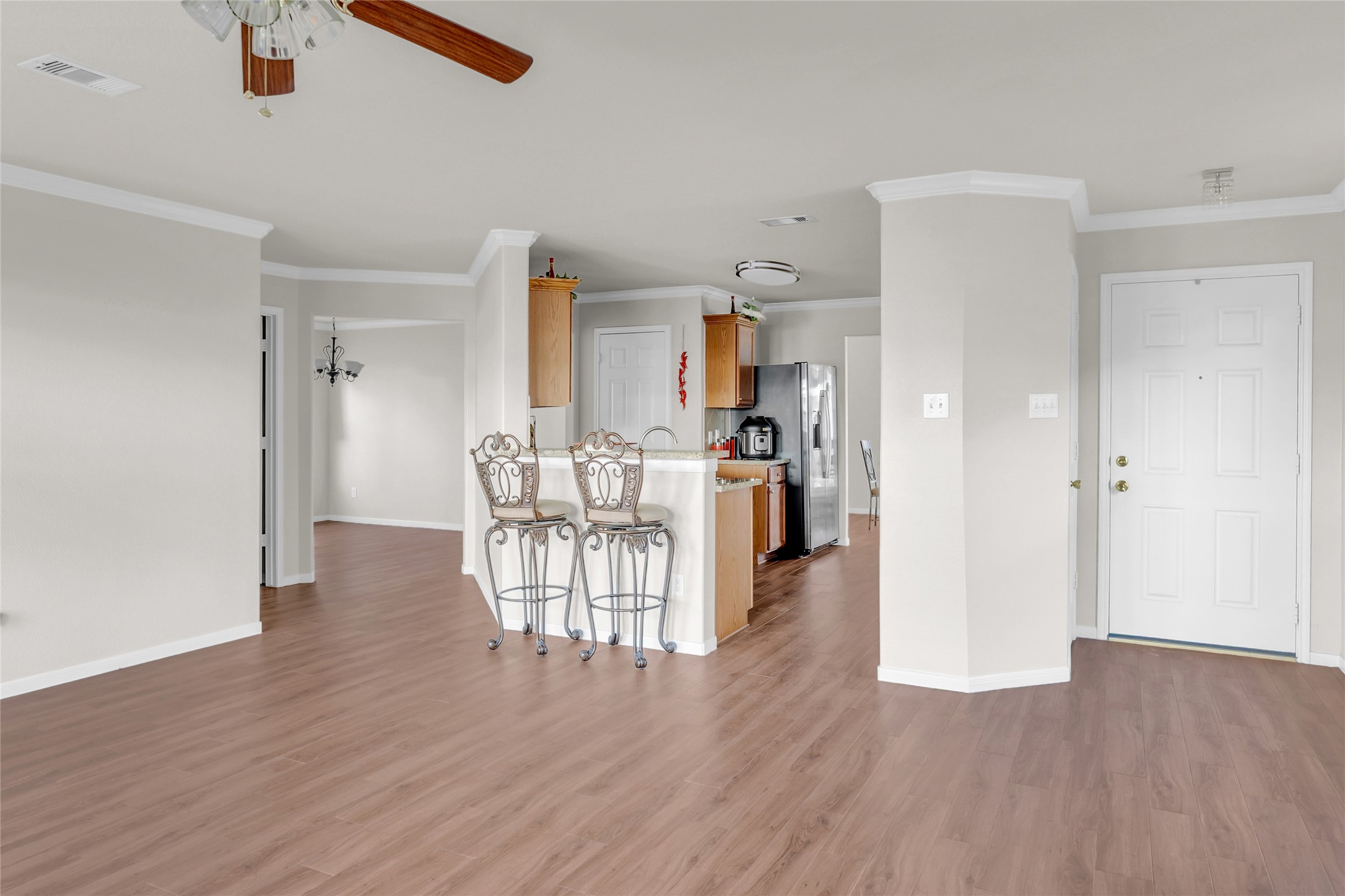 5018 Mabry Stream Court Katy, TX 77449 - Photo 13 of 31 Bright, open-concept living space featuring LVP flooring, neutral walls, and a ceiling fan.