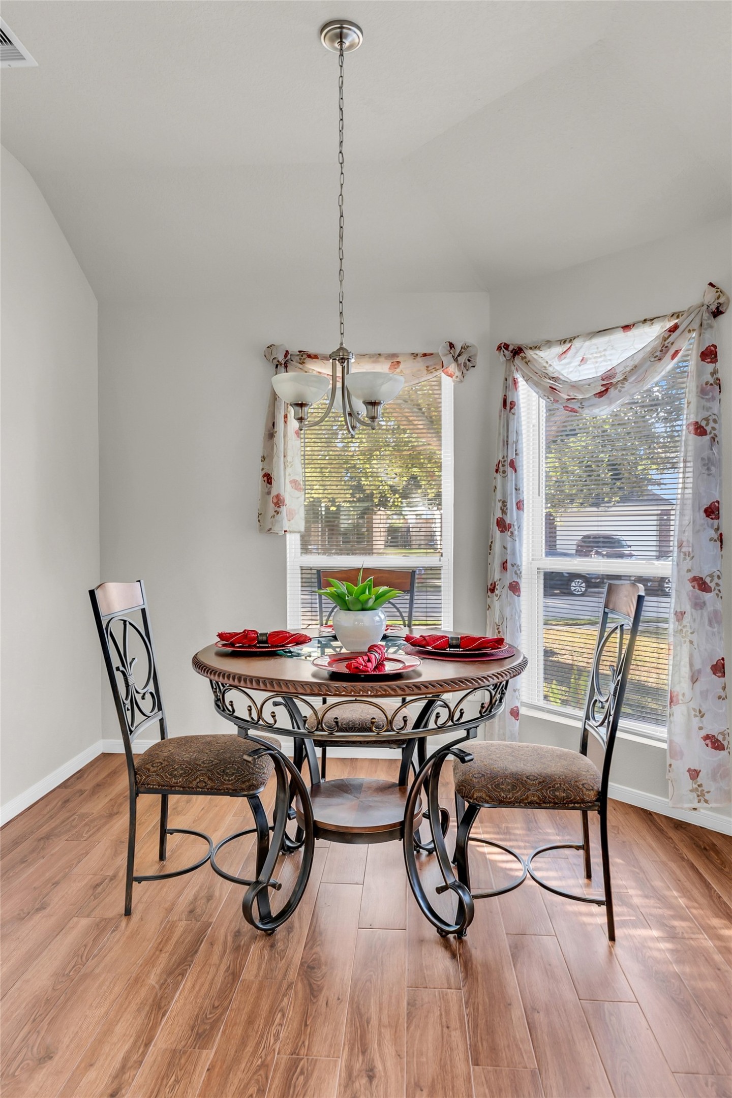 5018 Mabry Stream Court Katy, TX 77449 - Photo 15 of 31 Bright kitchen nook with LVP flooring. Features a large window with floral curtains allowing natural light, and a stylish overhead light fixture. Perfect for cozy meals.