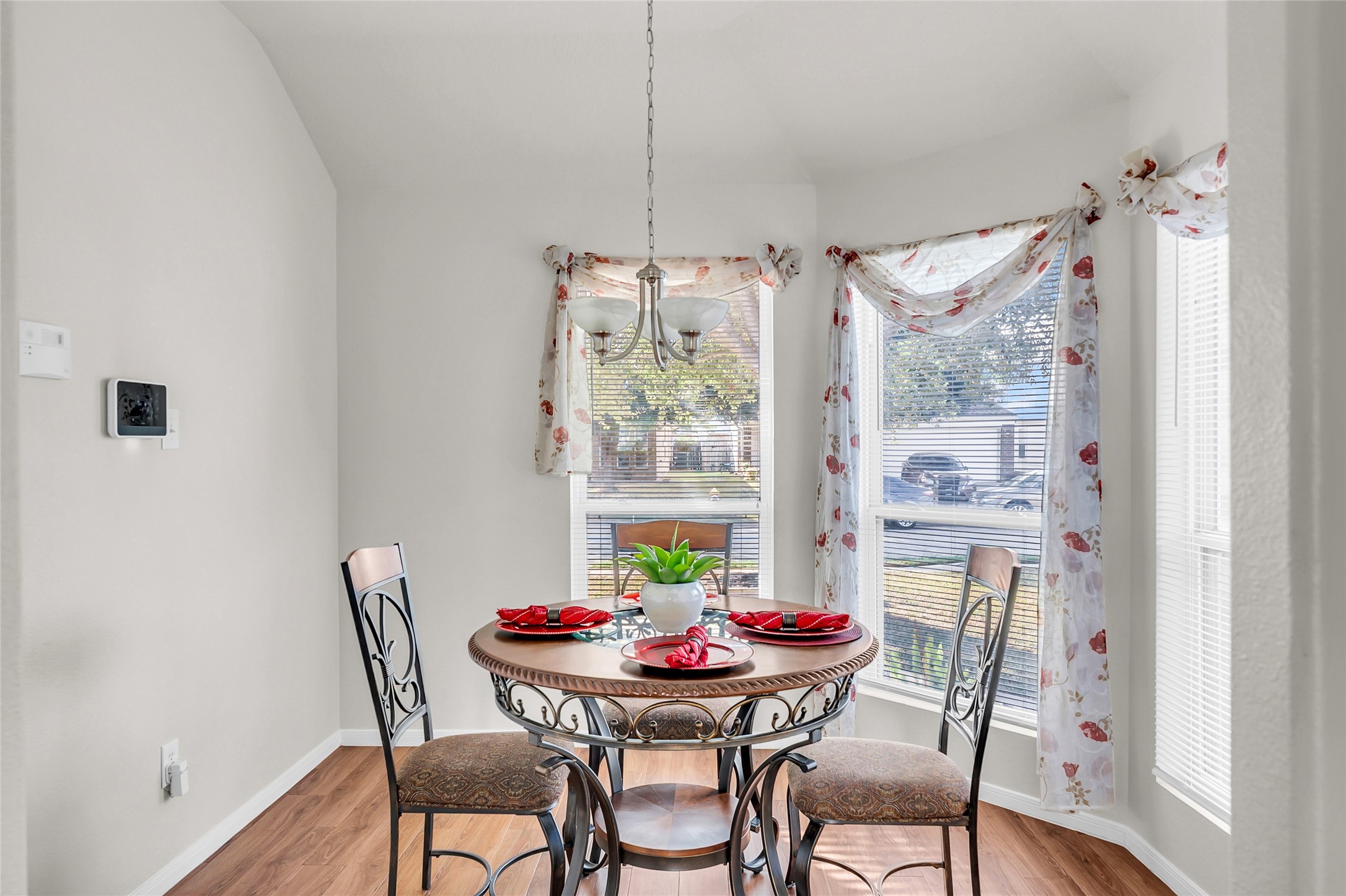 5018 Mabry Stream Court Katy, TX 77449 - Photo 16 of 31 Bright and inviting breakfast nook with large windows, floral curtains, and a cozy round table perfect for intimate meals. The space is enhanced by a stylish hanging light fixture.