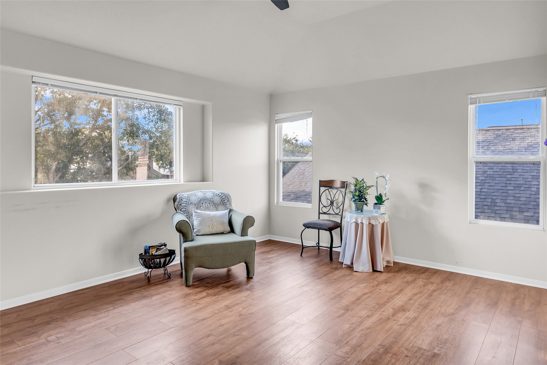 5018 Mabry Stream Court Katy, TX 77449 - Photo 21 of 31 Bright, spacious room with large windows LVP floors, offering a cozy reading nook with an armchair and accent table. Ideal for relaxation and natural light.