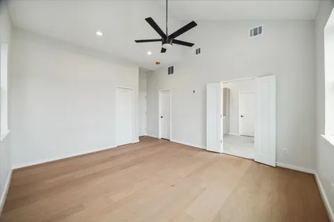 an empty room with closet and ceiling fan
