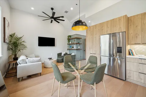 a living room with furniture a ceiling fan and a flat screen tv