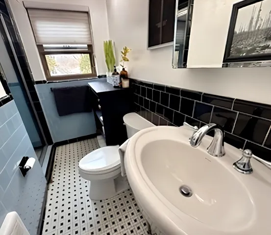 a bathroom with a sink toilet and window