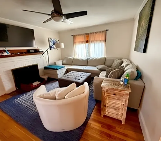 a living room with furniture a flat screen tv and a fireplace