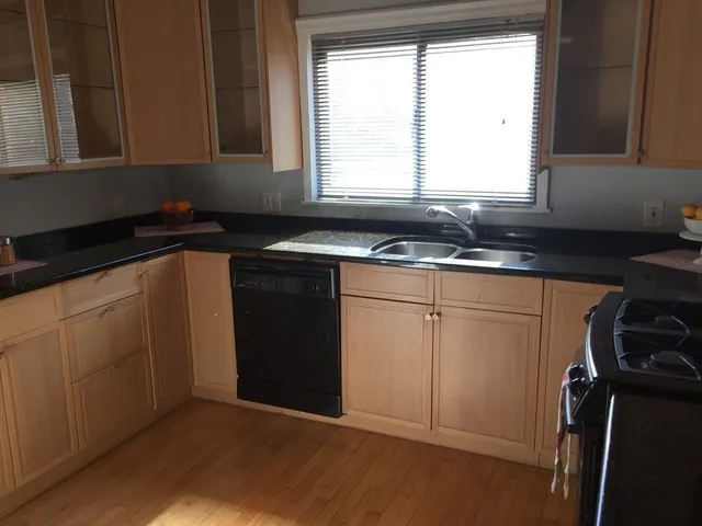 a kitchen with a sink window and cabinets