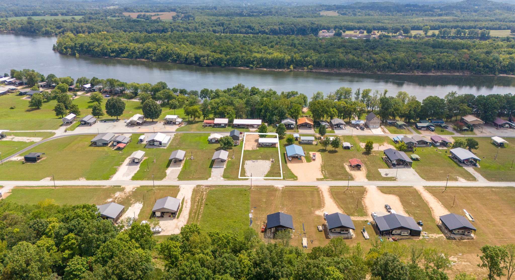 an aerial view of a residential houses with outdoor space and lake view