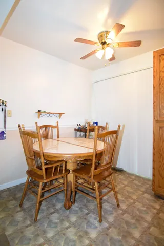 a view of a dining room with furniture and a chandelier fan