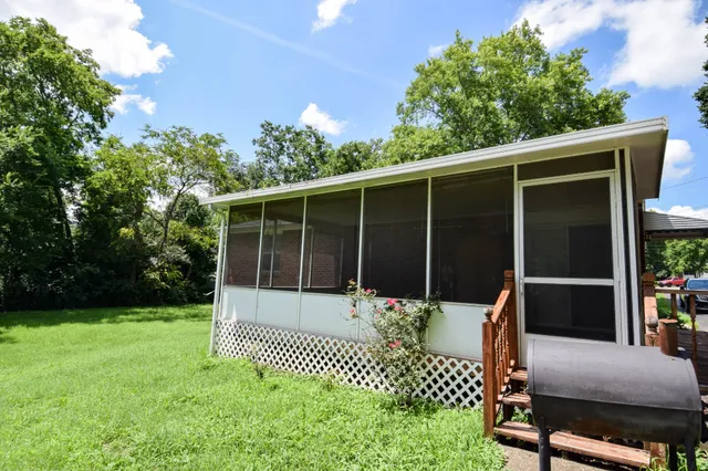 a view of a chair and table in the back yard of the house