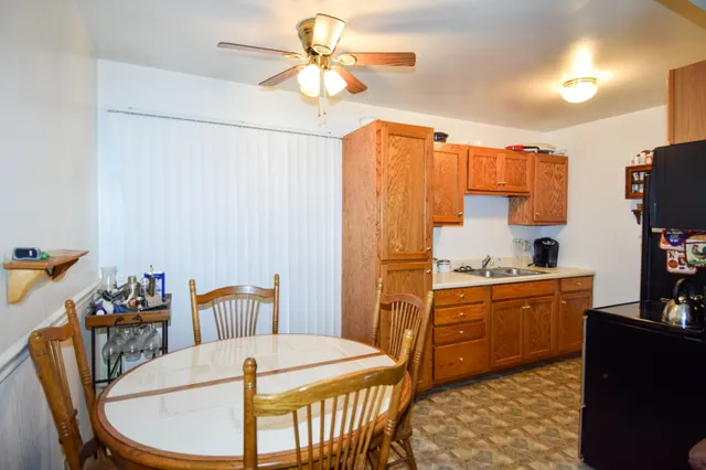 a kitchen with stainless steel appliances granite countertop a sink a stove a dining table and chairs