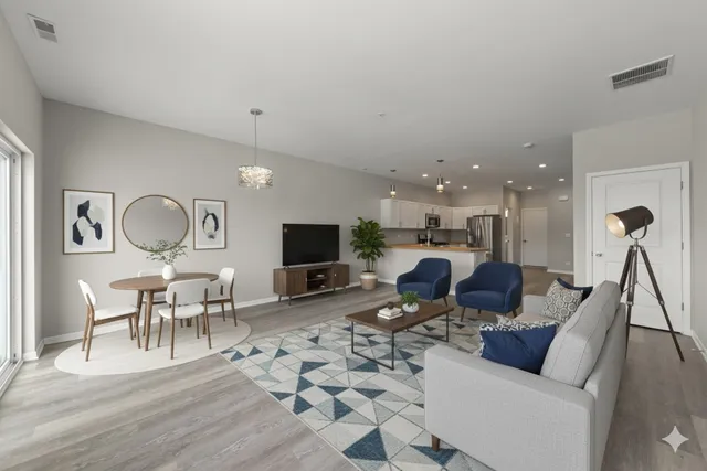 a living room with furniture a flat screen tv and kitchen view