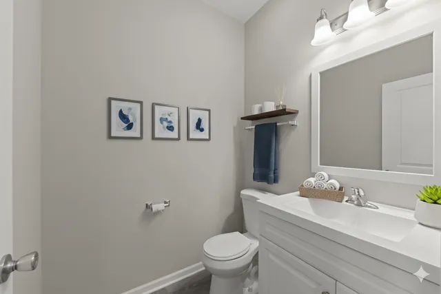 a bathroom with a granite countertop toilet sink and a mirror