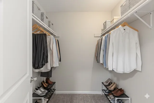 a view of walk in closet with clothes and shoes