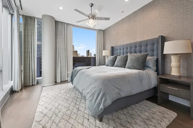 a bedroom with a large bed and a chandelier