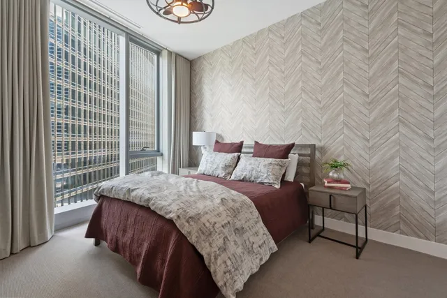 a bed sitting in a bedroom next to a window