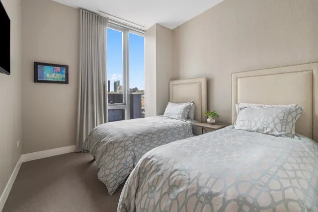 a bedroom with two beds and a lamp