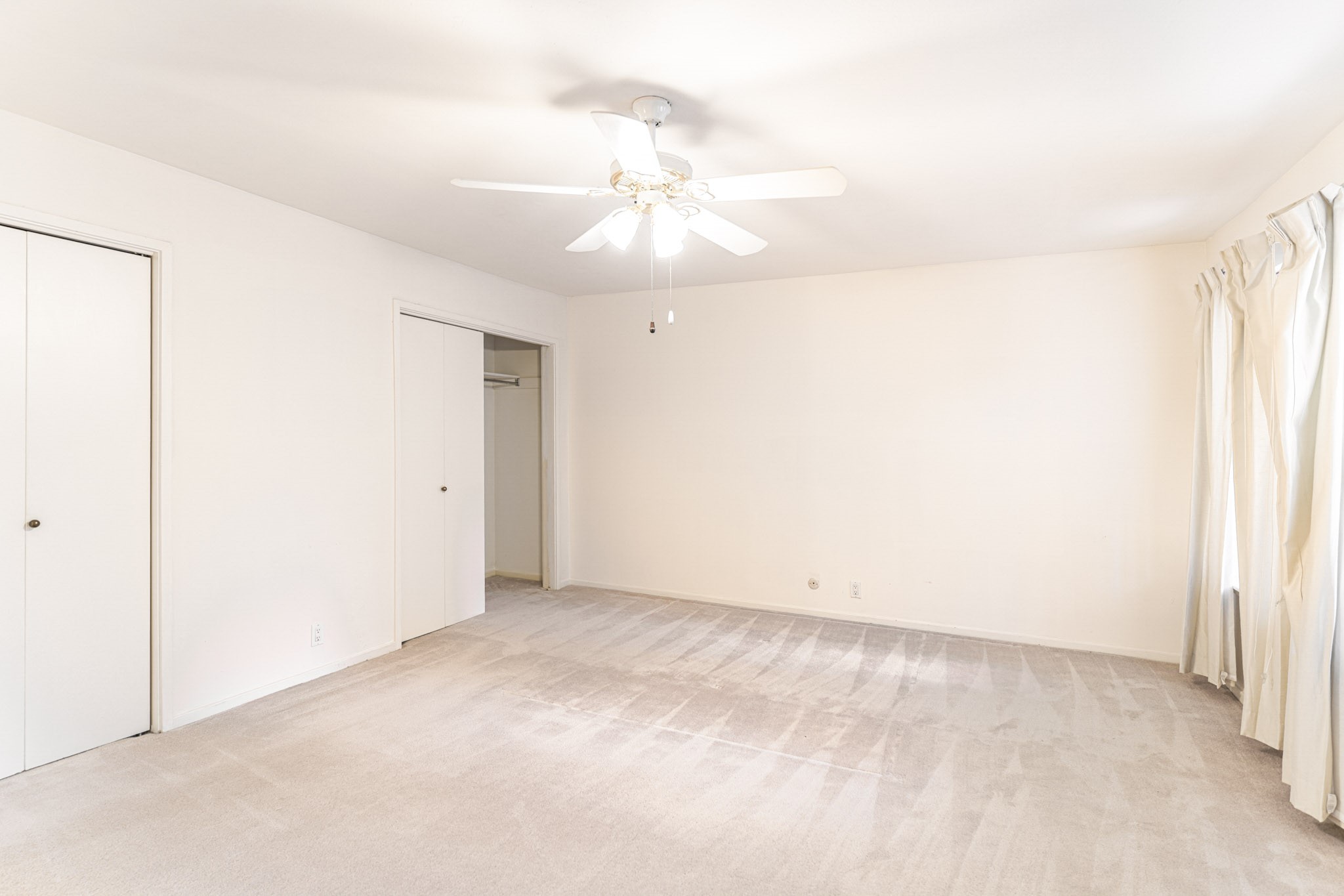 152 Litchfield Lane Houston, TX 77024 - Photo 24 of 33 an empty room with a ceiling fan and a window