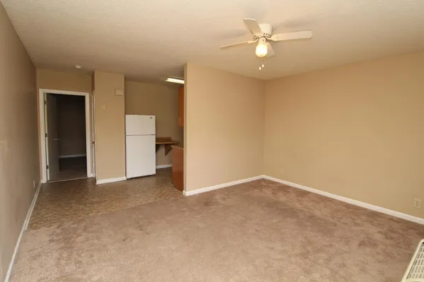 an empty room with a ceiling fan and a window