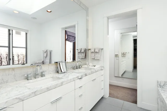 a bathroom with double vanity and a mirror